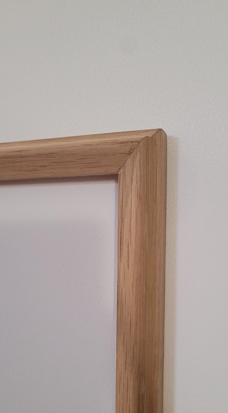 Peut inclure: Gros plan sur le coin d'un cadre photo en bois naturel. Le cadre est en bois massif avec une finition brun clair.