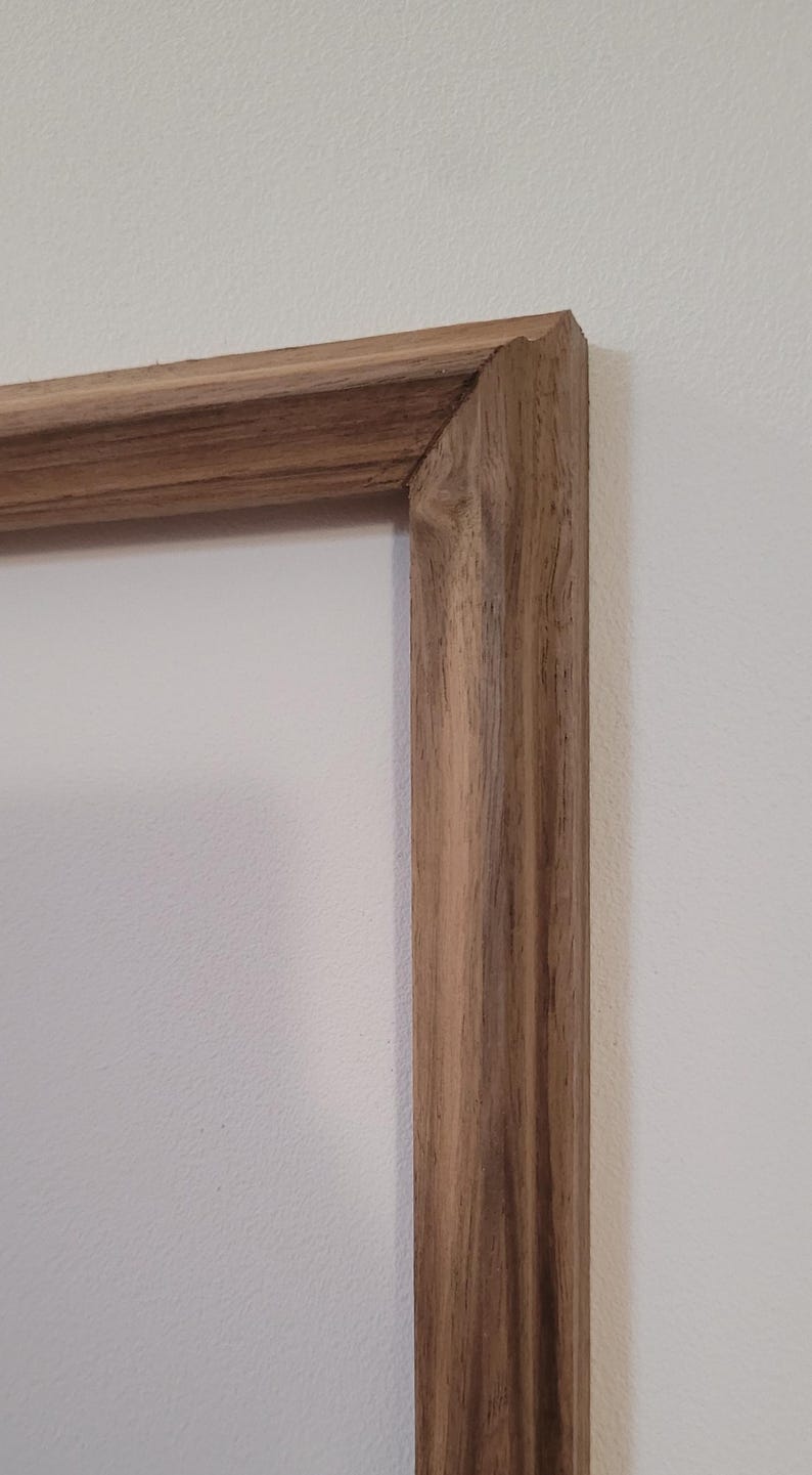 Peut inclure: Gros plan sur un cadre photo en bois avec une finition en bois naturel. Le cadre a un design simple et classique avec un bord l&eacute;g&egrave;rement sur&eacute;lev&eacute;.