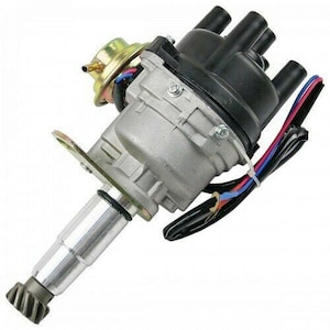 Puede incluir: Un distribuidor de encendido automotriz plateado y negro con una tapa de plástico negro y cuatro cables eléctricos. El distribuidor tiene un eje de metal plateado con una tapa de plástico negro en el extremo.