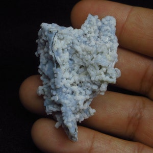 Puede incluir: Una geoda de &aacute;gata azul y blanca con un c&uacute;mulo de cristales blancos. La geoda es rugosa y tiene una forma natural y org&aacute;nica.