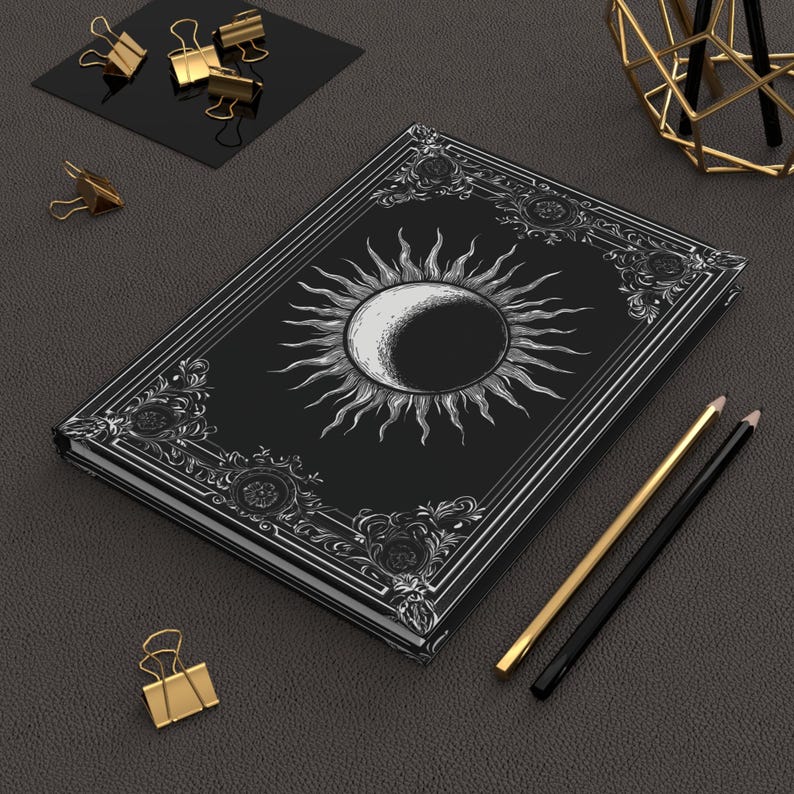 Let your thoughts drift into the mystical with this Gothic Sun & Moon Eclipse Journal. The ornate vintage border and celestial centerpiece make it the perfect notebook for witches, poets, and dark academia lovers alike.