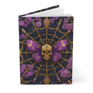 Hardcover journal featuring an ornate gothic design of a golden skull with purple butterfly wings at the center of a golden spiderweb. Surrounded by rich purple flowers, butterflies, and intricate details, all set against a dark, swirling background.