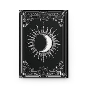 Let your thoughts drift into the mystical with this Gothic Sun & Moon Eclipse Journal. The ornate vintage border and celestial centerpiece make it the perfect notebook for witches, poets, and dark academia lovers alike.