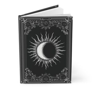 Let your thoughts drift into the mystical with this Gothic Sun & Moon Eclipse Journal. The ornate vintage border and celestial centerpiece make it the perfect notebook for witches, poets, and dark academia lovers alike.