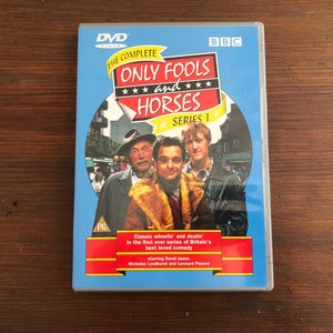 Pode incluir: DVD de "Only Fools and Horses, Série 1" com o logotipo da BBC. A capa apresenta três homens em frente a uma cena de rua. O texto inclui "Classic wheelin' and dealin'" e os nomes dos atores. O DVD está em uma capa de plástico transparente.