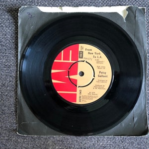 Può includere: Un disco in vinile nero con un'etichetta rossa e bianca, con il testo "From New York To L.A." e "Patsy Gallant". Il disco è in una custodia di carta nera usurata. L'etichetta include anche il testo "MANDY."