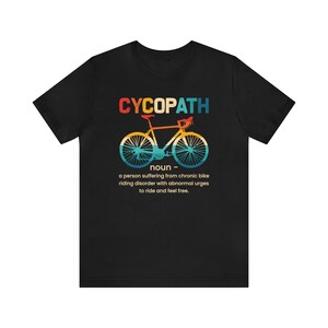 May include: Black t-shirt with a vintage-style graphic of a bicycle and the text "CYCOPATH" defined as "a person suffering from chronic bike riding disorder with abnormal urges to ride and feel free."