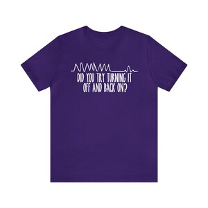 May include: A purple t-shirt with white text and a graphic resembling a heart rate monitor. The text reads, "DID YOU TRY TURNING IT OFF AND BACK ON?"