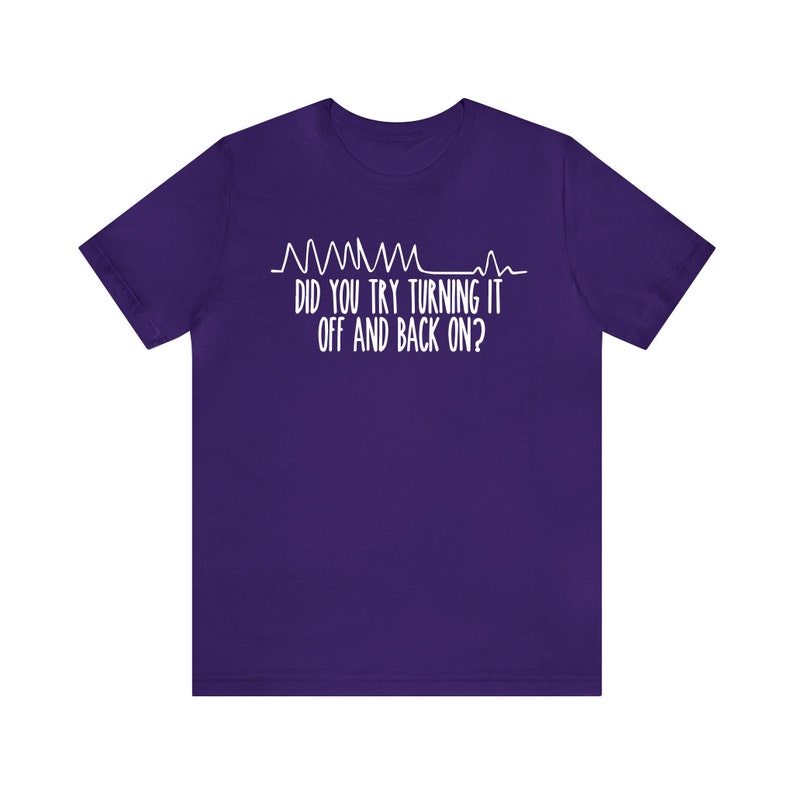 May include: A purple t-shirt with white text and a graphic resembling a heart rate monitor. The text reads, "DID YOU TRY TURNING IT OFF AND BACK ON?"