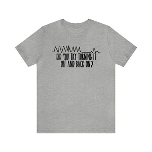 May include: A heather gray t-shirt with black text and a graphic of a heartbeat. The text reads, "DID YOU TRY TURNING IT OFF AND BACK ON?" A humorous design for tech enthusiasts.