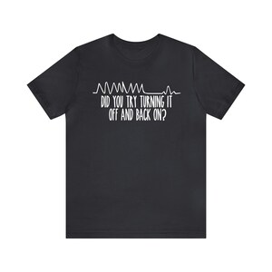 May include: Black t-shirt with white text and a graphic resembling a heart rate monitor. The text reads, "DID YOU TRY TURNING IT OFF AND BACK ON?" A humorous design for tech enthusiasts.