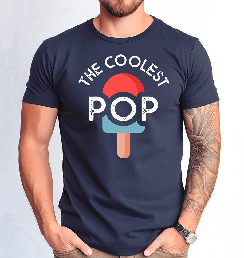 Puede incluir: Camiseta azul marino con el texto "THE COOLEST POP" sobre un gr&aacute;fico de paleta. El dise&ntilde;o de la paleta presenta colores rojo, azul claro y naranja. La camiseta es de cuello redondo y manga corta.
