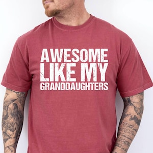May include: Red t-shirt with white text that reads "Awesome Like My Granddaughters".