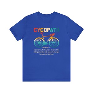 May include: A blue t-shirt with a graphic of a bicycle and the text "CYCOPATH" in rainbow colors. The text below the graphic reads "noun - a person suffering from chronic bike riding disorder with abnormal urges to ride and feel free."