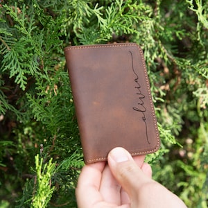 May include: A brown leather wallet with the name "Olivia" engraved on the front.
