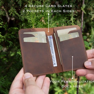 May include: A brown leather wallet with four card slots and two pockets on each side. The wallet is open and has a few cards and cash inside. The text "YOUR PERSONALIZATION GOES HERE" is printed on the bottom of the wallet.