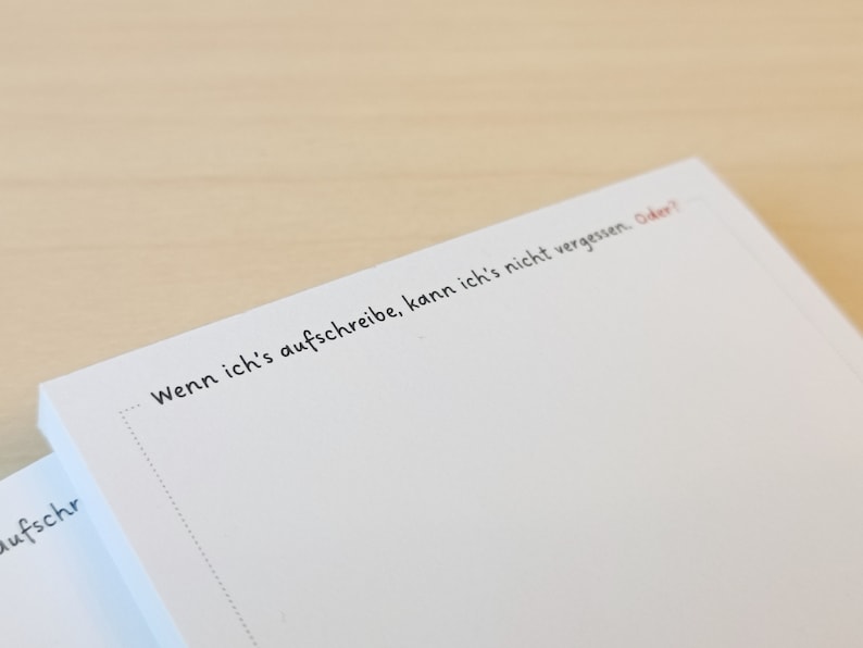 May include: A white notepad with the text "Wenn ich's aufschreibe, kann ich's nicht vergessen. Oder?" written on it.
