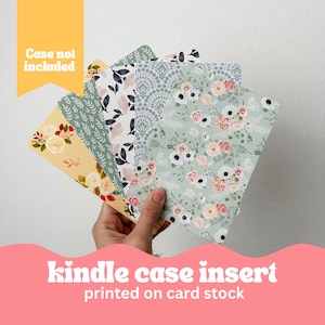 May include: Set of five floral patterned cardstock inserts for a Kindle case. The patterns include a green and white floral design, a blue and white geometric pattern, a green and white leaf pattern, a yellow and white floral pattern, and a black and white floral pattern. The text "Case not included" is visible in the top left corner of the image. The text "kindle case insert printed on card stock" is visible at the bottom of the image.