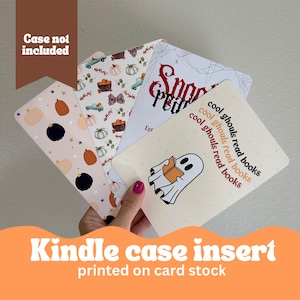 May include: Four different Halloween-themed Kindle case inserts printed on card stock. The designs include pumpkins, stars, a ghost reading a book, and the text "cool ghouls read books".