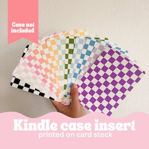 May include: A hand holds a fan of Kindle case inserts, each with a different color checkerboard pattern. Colors include black, pink, orange, green, blue, and purple. Text at the bottom reads "Kindle case insert printed on card stock."