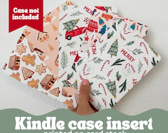 May include: Kindle case inserts with festive Christmas patterns. Designs include gingerbread houses, trees, candy canes, and a red truck. The text "Merry" is visible on the inserts. The inserts are printed on card stock.