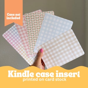May include: Set of five patterned paper inserts for a Kindle case. The patterns include gingham in pink, blue, and brown, and a floral pattern with pink flowers on a green background. The text "Case not included" is visible in the image.