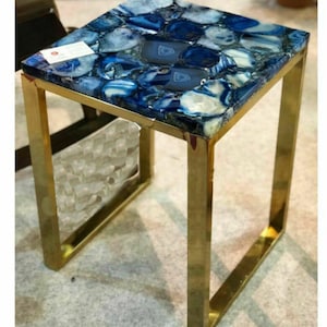 May include: A square side table with a blue agate top and a gold metal frame. The table is made of natural stone and metal.