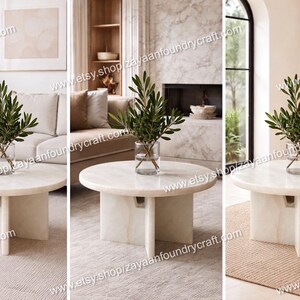 May include: A set of three images showcasing a modern living room with a round, off-white marble coffee table. The table has a pedestal base. Each table holds a clear vase with green leafy branches. The room features neutral tones and natural light.