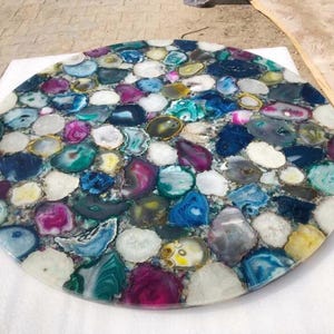 Könnte beinhalten: Runder Tischplatte aus Achat, mit einer Vielzahl von Farben und Mustern, darunter Blau, Grün, Lila und Weiß.
