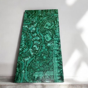 Puede incluir: Una bandeja rectangular grande hecha de malaquita, una piedra preciosa verde. La bandeja tiene un patrón orgánico y en espiral y un acabado pulido.