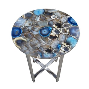 May include: Round side table with a blue and brown agate stone top and a stainless steel base.