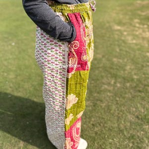 Peut inclure: Pantalon patchwork coloré avec un mélange de motifs et de couleurs, dont le blanc, le vert et le rouge. Le pantalon a une taille élastique et une coupe décontractée. Le tissu semble être matelassé ou cousu, ajoutant de la texture et des détails.