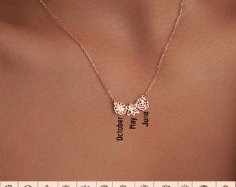 May include: A gold necklace with a delicate chain and five small flower charms. The charms are arranged in a crescent shape and each charm represents a different month of the year. The months are labeled "October", "May", and "June".