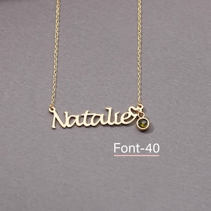 May include: Gold necklace with the name "Natalie" in a cursive font and a small green gemstone pendant. The text "Font-40" is below the necklace.