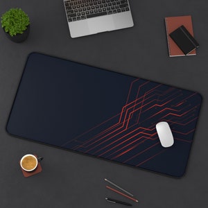 Könnte beinhalten: Eine schwarze und rote Gaming-Mausmatte mit einem Leiterplatten-Design. Eine weiße kabellose Maus liegt auf der Matte.