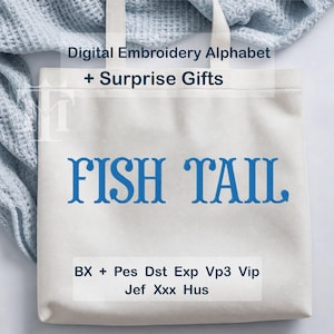 May include: A white tote bag with the words "FISH TAIL" in blue, stylized lettering. The bag also features the text "Digital Embroidery Alphabet + Surprise Gifts" and a list of file formats. The bag has a light blue fabric handle.