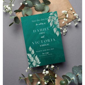 May include: Save the date card with a teal green background and white floral design. The card announces the wedding of Daniel Smith and Victoria Johnson on Tuesday, July 20th, 2027. The card includes the time and date of the wedding and the address of the venue.