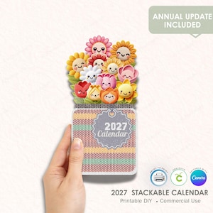 Può includere: Un calendario impilabile 2027 con un motivo a maglia colorato e un bouquet di personaggi floreali sorridenti. Il calendario ha il testo "2027 Calendar" e include il testo "Annual Update Included".