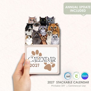 Könnte beinhalten: Ein stapelbarer Kalender 2027 mit Illustrationen verschiedener Katzenrassen und -farben. Der Kalender hat ein Pfotenabdruck-Design und das Wort "CALENDAR" ist auf der Vorderseite aufgedruckt. Der Text "ANNUAL UPDATE INCLUDED" ist ebenfalls sichtbar.