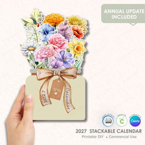 Puede incluir: Calendario apilable 2027 con diseño floral. El calendario tiene forma de tarro lleno de flores coloridas y atado con una cinta marrón. El texto "FOR YOU" y "Calendar" son visibles en la etiqueta.