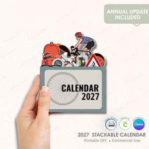 May include: A printable 2027 stackable calendar with a bicycle theme. The design includes a cyclist, a backpack, and a road sign. The calendar is held by a hand and features the text "CALENDAR 2027".