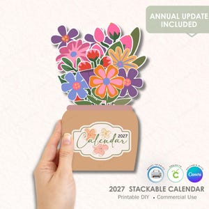 May include: A colorful 2027 stackable calendar featuring a bouquet of flowers in a vase. The flowers are in shades of pink, orange, purple, and blue. The calendar has the text "Calendar 2027" and includes the text "Annual Update Included".