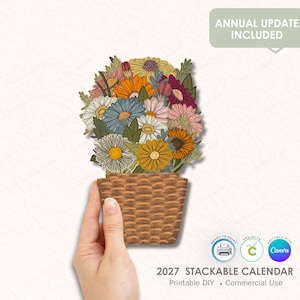 Puede incluir: Un colorido arreglo floral en un diseño de cesta tejida. El ramo presenta margaritas y otras flores en tonos amarillos, naranjas, azules y rosas. El texto dice "2027 Stackable Calendar" y "Annual Update Included."