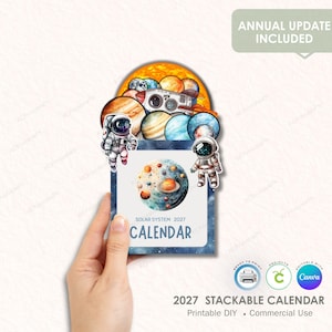 Puede incluir: Un calendario apilable de 2027 con temática del sistema solar. El diseño incluye planetas, astronautas y una nave espacial, con el texto "SOLAR SYSTEM 2027 CALENDAR". Diseñado para proyectos DIY imprimibles y uso comercial.