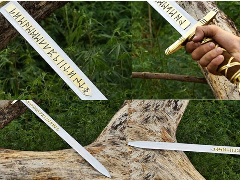 May include: A silver sword with a gold hilt and a brown leather-wrapped handle. The blade has etched gold lettering. The sword is displayed against a backdrop of green foliage and a tree trunk.
