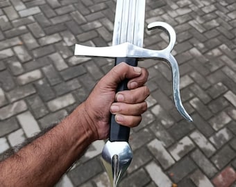 May include: A silver and black sword with a curved guard and a pointed tip. The blade is long and has a central fuller. The handle is black and the sword is held in a hand.