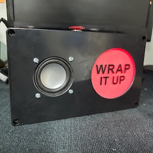 May include: A black box with a red button that says "WRAP IT UP" and a speaker on the left side.