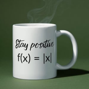 May include: White ceramic mug with the text "Stay positive f(x) = |x|" in black script. The mug has a curved handle and is set against a green background. Steam rises from the top of the mug.