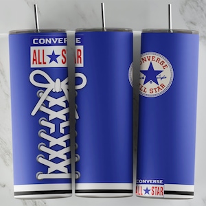 May include: Three blue stainless steel tumblers with silver straws. One tumbler features a white shoelace design, while the others display the Converse All Star logo. Each tumbler has a white stripe at the base and the text "CONVERSE ALL STAR".