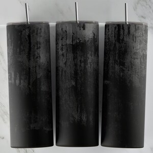 May include: Three black stainless steel tumblers with a distressed, textured finish. The tumblers have lids and straws.